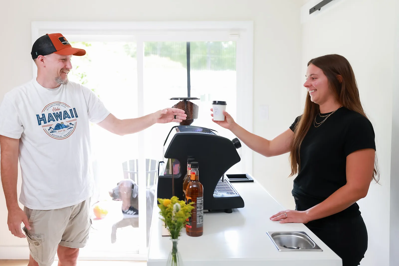 Barista handing a hot coffee across the cart to a guest