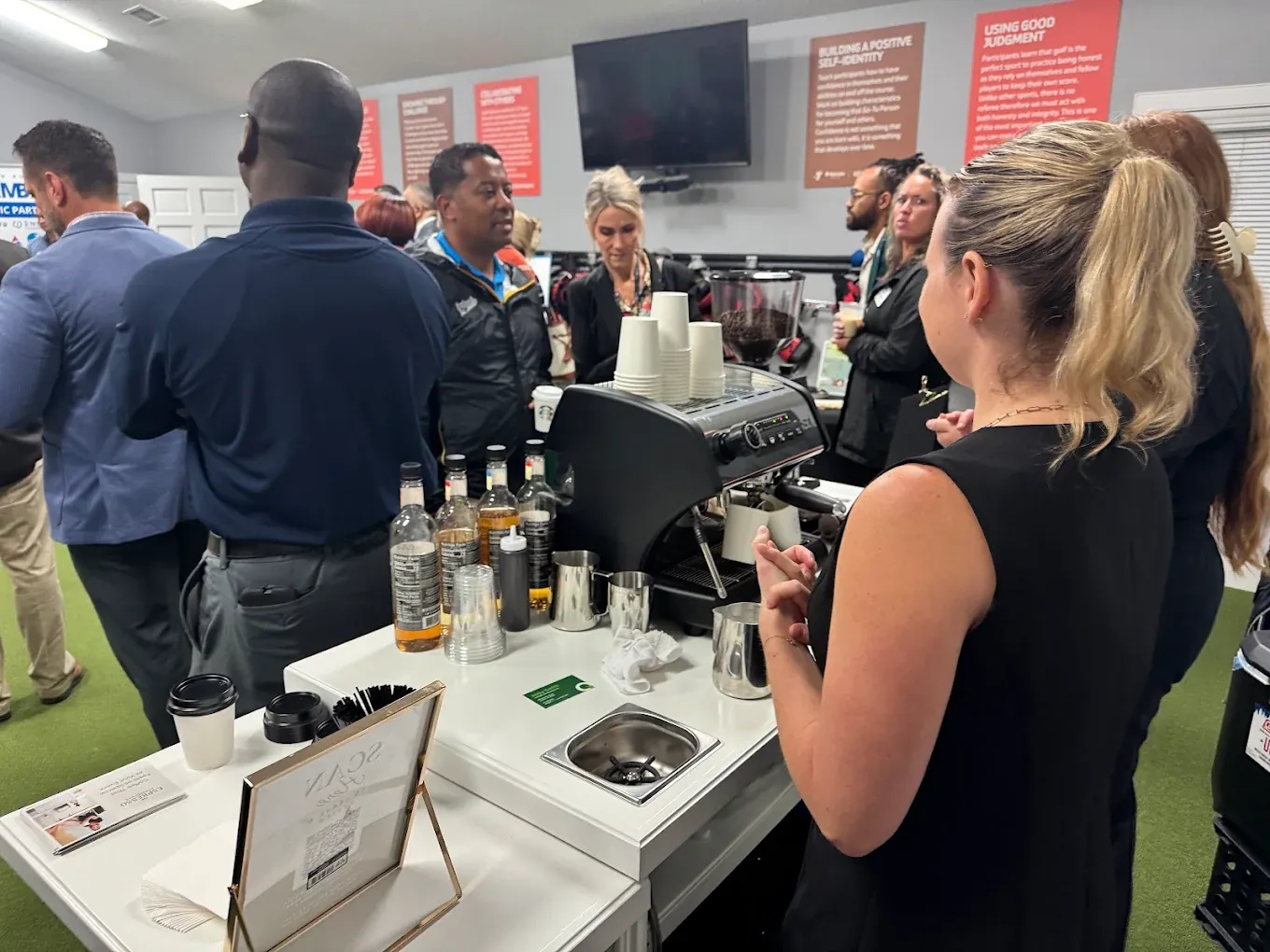 Barista making espresso drinks for a crowd of guests at a corporate event