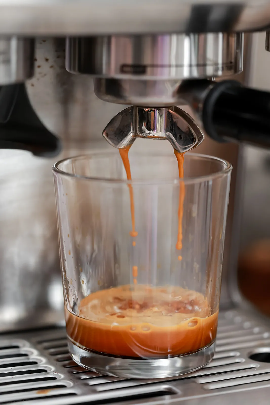 Espresso shot pulling into a glass on an Italian espresso machine
