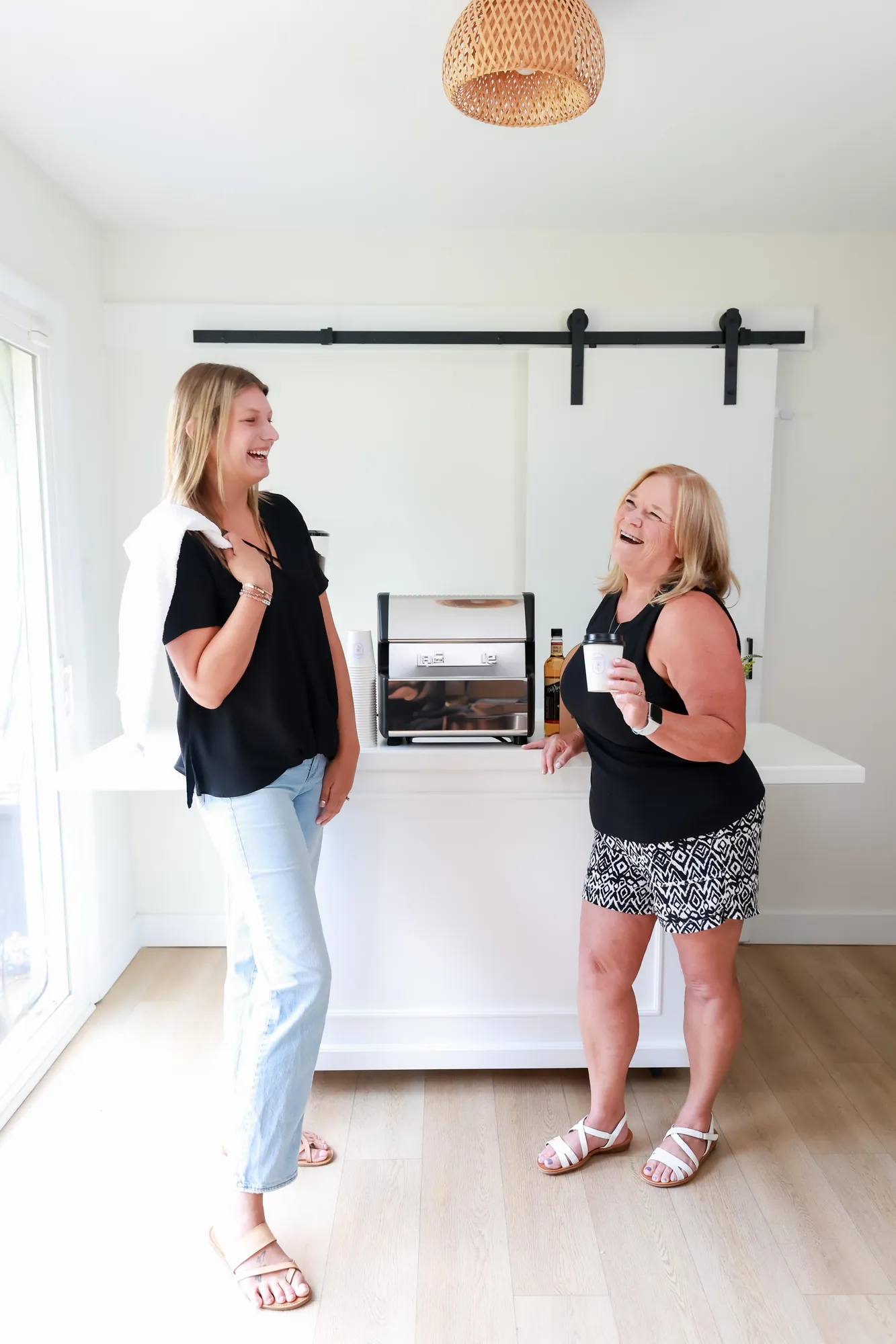 Two guests laughing together in front of the coffee cart